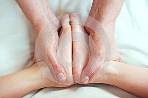 Masseur massaging a child leg photo