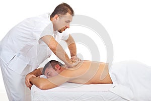 Masseur massaging man back at spa