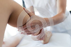 Masseur massaging the pregnant woman`s legs in spa center