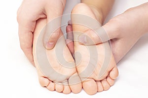 Masseur massaging a small childrens foot. Mother is doing massage on her baby foot.