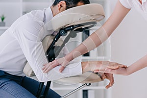 masseuse doing arm massage for businessman photo