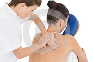 Masseuse giving massage to naked woman