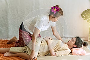 Masseuse woman therapy massage young girl at spa salon. Beautiful young woman lying on the pillow receiving masseuse