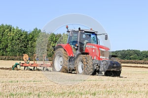 Massey Ferguson 7726 ploughing on stubble in crop field