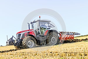 Massey Ferguson 7726 ploughing on stubble in crop field