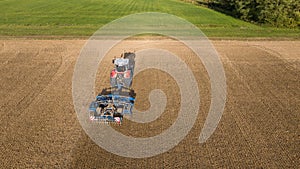 A Massey Ferguson Velox Ker 8S.265 tractor pulls the disc harrow through the field to prepare the soil photo