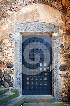 Massive antique outside wooden door of a chateau, castle with many small square windows