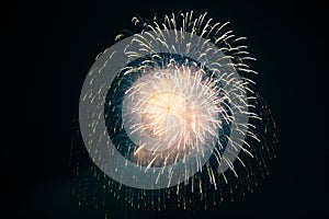 A massive cloud of firework sparks fills the night sky, with countless bright particles spreading outward, creating a dynamic and