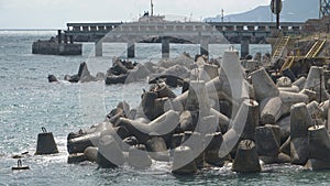 Massive concrete tetrapods form in the blue water sea