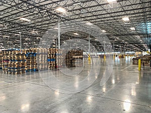 Massive Empty Industrial Warehouse Interior With Stacked Pallets