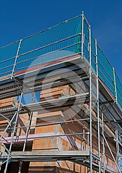 Massive home in shell construction with scaffolding, portrait format