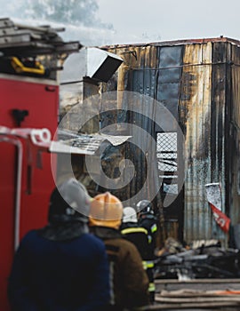 Massive large blaze fire in the city, blazing warehouse factory, storage building is burning, firefighters team putting out the