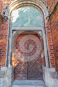 Massive old great door to the church, entrance to the temple in Torun Poland