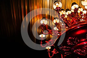 Massive pretentious chandelier on dark golden background photo