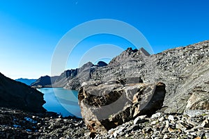 A massive rock with scenic view on the mountains of Hohe Tauern Alps in Carinthia, Austria, Europe. Lake reflection and water