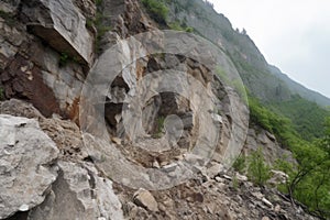 massive rockslide from cliff, with jagged rock fragments and dust