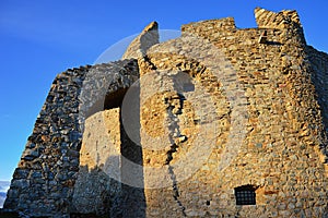 Mohutná okrúhla delová bašta s oblúkom pri južnom vchode do hradu Hrušov, stredné Slovensko.