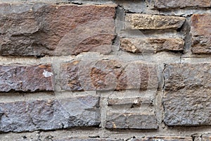 Massive stone wall with rough rocks like a castle wall with different bricks as natural background and rocky wall of ancient times