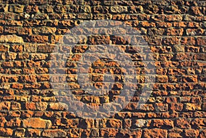 Massive stone wall with brown, orange, yellow colors