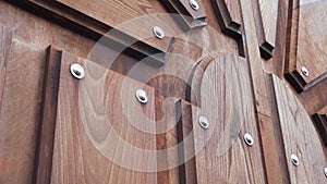 Massive textured wooden door with metal rivets. Relief old gate with geometric ornament