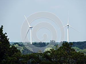 Massive Wind Turbines tower over tree line in FingerLakes