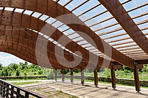 Massive wood beams roof structure with S curved shaped and covered with transparent polycarbonate sheet