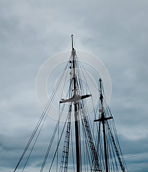 Mast of a caravel over a cloudy sky.