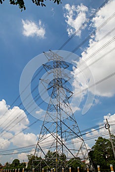 Mast electrical power line against cloud and blue sky.