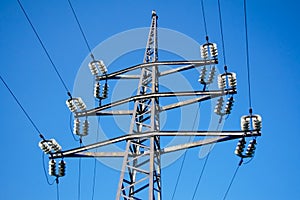Mast of a high-voltage power line against the blue sky