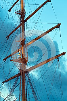 The mast of a large sailing ship against the background of the heaven, vertical photo