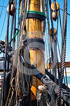 Mast of old wooden Age of sail sailing ship with ropes cordage. and shroud