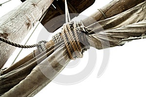 Mast of pirate ship with old sails tied rope isolated