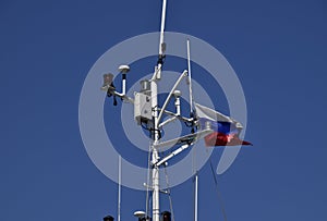 Mast of the port service ship. Devices of light signaling and communication antenna.