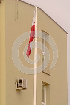 Polish flag hanging on the flagpole. No flauta wind. photo