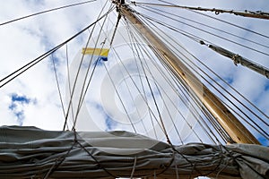 Mast, ropes and sails collected from an old sailboat seen from below