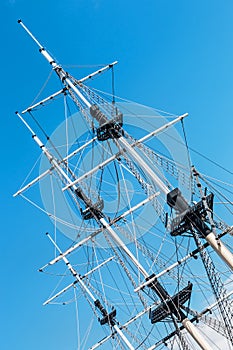 The mast of a sailboat against a blue sky