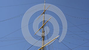 The mast of a sailboat against a clear blue sky. photo