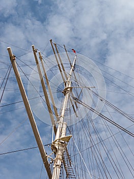 Mast of a sailing ship at cloudy sky.