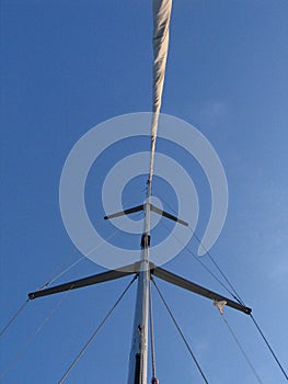 The mast of a sailing ship with its sails furled