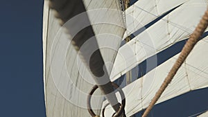 Mast with sails and ropes on old sail ship. View from bow.