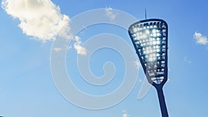 Mast with spotlights illuminate on the stadium. Classic blue sky background. Space for text. Sport concept