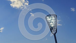 Mast with spotlights illuminate on the stadium. Classic blue sky background. Sport concept