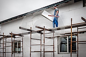 Master with adhesive Styrofoam to the wall by facade. Building insulation saves energy