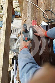 Master angular grinder trims corrugated flooring on the roof