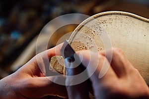 Master artisan luthier working on the creation of a violin. painstaking detailed work on wood.