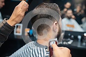 Master in barbershop makes men& x27;s haircutting with hair clipper