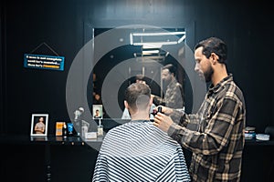 Master in barbershop makes men& x27;s haircutting with hair clipper