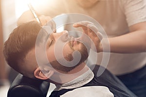 A master in the barbershop works with the client