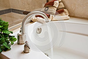 Master bathroom bathtub with running water photo