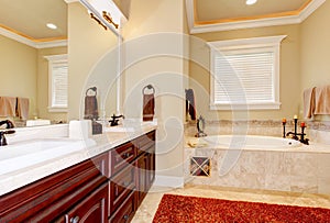 Master bathroom interior with cherrywood cabinets.